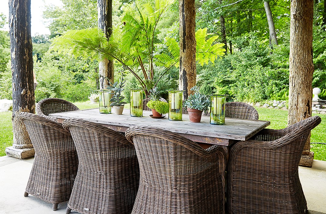 Bunny hosts many summer lunches in the pool house at the 19th-century French farm table, which is grouped with wicker dining chairs by Vandecasteele Marc & Co.
