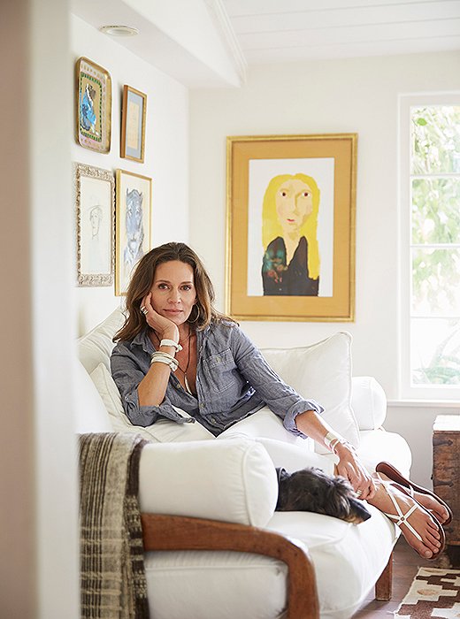 In her office, which she describes as “the most ‘me’ room in the house,” Kendall sits with one of her wirehaired dachshunds, Ollie. Her jewelry and sandals are from her chic accessories line. The portrait in the background is by daughter Luisa.
