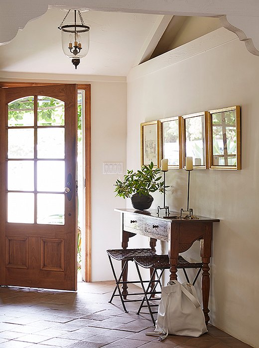 “This entry introduces you to the house, so you get the vibe right off the bat,” says Kendall. The airy, edited space has a Colombian credenza, woven leather stools, and iron candlesticks from a shop on Portobello Road in London. A Kendall Conrad L’Aventura bag rests on the stone floor.
