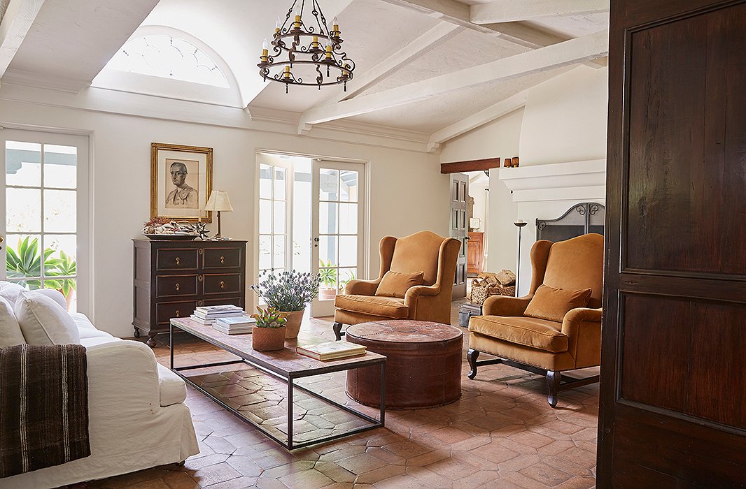 Kendall and David painted many of the dark exposed beams white to lighten things up. A George Smith sofa and two vintage armchairs suit the long rectangular room. The large leather ottoman? “It’s a Kendall Conrad original,” she says.
