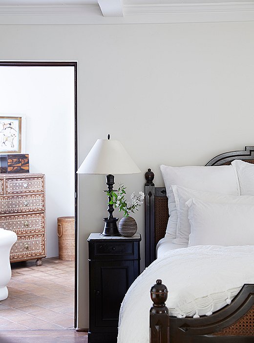 The master suite is a serene, breezy retreat. The centerpiece is a striking wood-and-wicker bed and set of nightstands “They’re custom by Brenda Antin and a future heirloom for our daughters,” Kendall says. Nightstand essentials? “Books, lip balm, and hand cream.” The bedding is Matteo.
