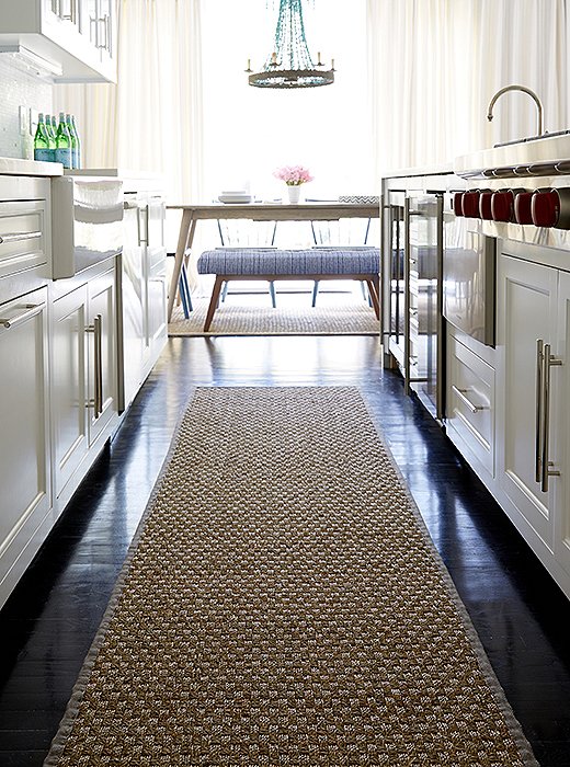 “I wanted to cut all the darkness of the floors,” Alex says, “so we lined each area with sea-grass rugs—they are inexpensive and durable.” And they feel good on the feet—especially in a place like the kitchen galley.
