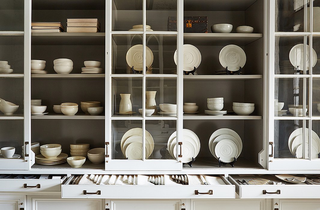 Primitive vessels, dishes, bowls, and tableware created by Darryl with ceramicist Ani Kasten fill the display case. Darryl designed the display around panel doors salvaged from the butler’s pantry of a historic Georgetown home.
