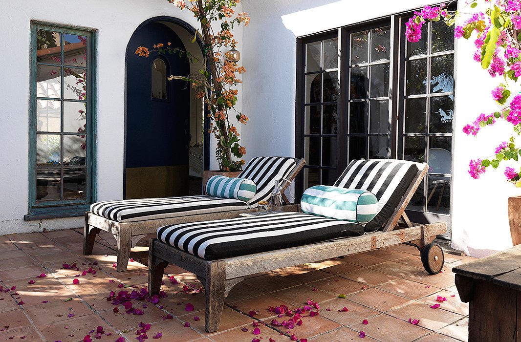 The chaises are placed by the front door by design. “That’s where the beautiful vistas are,” says Heidi. “We can spend an entire Saturday lying on them.” Heidi ordered the cushion fabric online and accessorized the chairs with pillows from her own collection.
