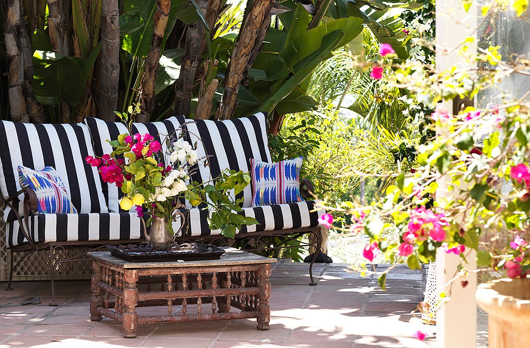 Unlike many other Angelenos, Heidi tends to her own gardens. “I’m a mad scientist with bougainvillea,” she laughs. “No… but I’m a good gardener.” Heidi likes free-form arrangements using things from the backyard. The iron settee was her grandmother’s. The silver teapot is a leftover from her wedding. “We had them on the reception tables. It’s a nice memory to have around.”
