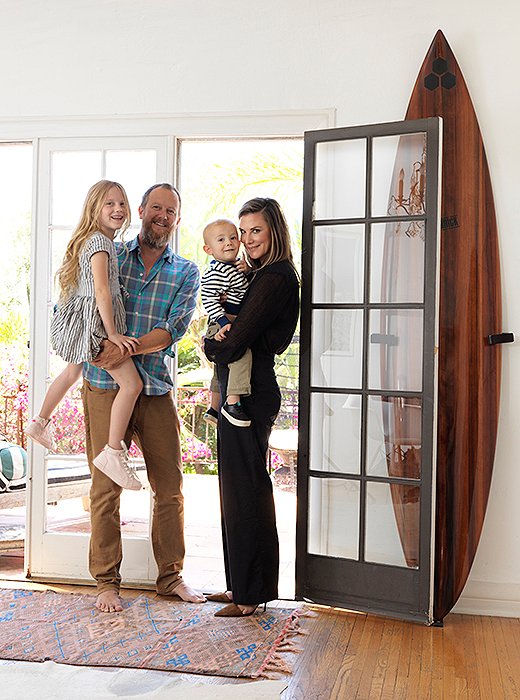 Heidi with Johnny, Hiver, and Alfie in their 1920s Spanish home. The surfboard was made by her father, surf icon and board shaper Al Merrick. “He made a few of them from a 3,000-year-old redwood. My brother and I both have one.”
