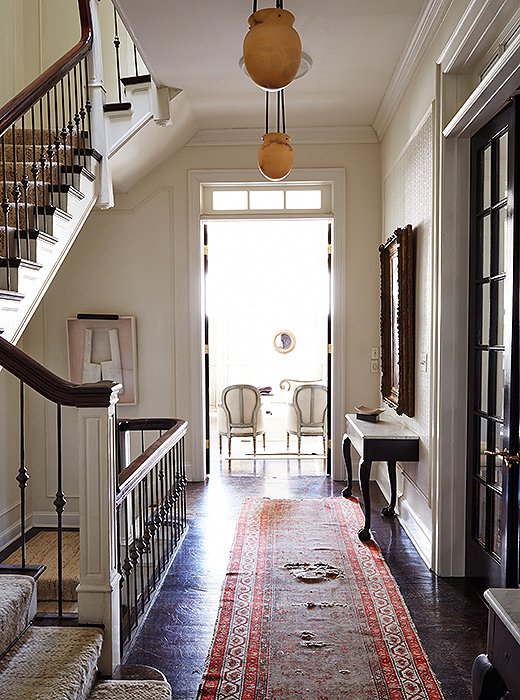 The airy second-floor landing, with its antique alabaster pendants and a gorgeous distressed runner, captures Darryl’s love of timeworn treasures that are none too precious. “My dog has done quite a number on all of my floors, both wood and stone.”
