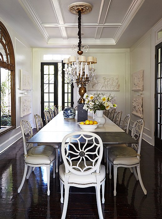 Darryl’s steel-and-concrete dining table is surrounded with hand-painted and -gessoed chairs chosen as a stylistic counterpoint to the table’s modern form. The seats, reupholstered with suede cushions, and a Murano glass chandelier complete the mood. “I had the candle sleeves raised, and the linen shades were custom for the piece,” he says.
