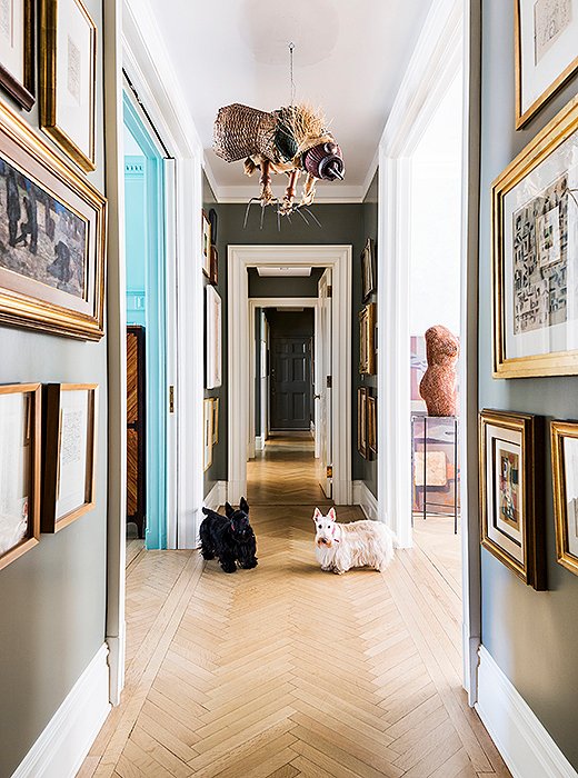 The hallway is dedicated to artwork, from the bird sculpture by Antonio Berni that hangs overhead to the collection of smaller framed pieces that line the walls salon-style. The paint color is what Roberta calls “museum gray,” a dusky greenish gray tone that makes the small paintings—and Roberta’s black and white Scottish terriers, Alfa and Romeo—stand out.
