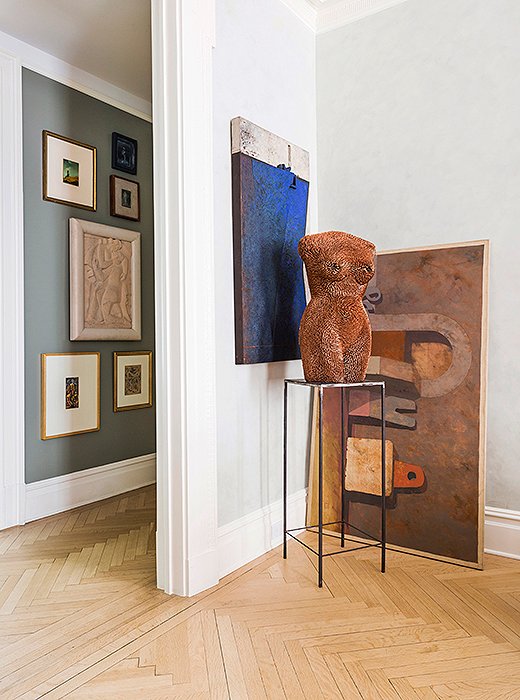 In this gallery-style corner, a simple metal pedestal allows a figurative sculpture to take the spotlight. Photo by Lesley Unruh.
