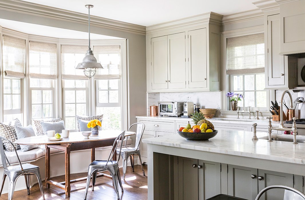 The breakfast area features a vintage Italian pendant light, an antique table, and Tolix-inspired galvanized-steel chairs.
