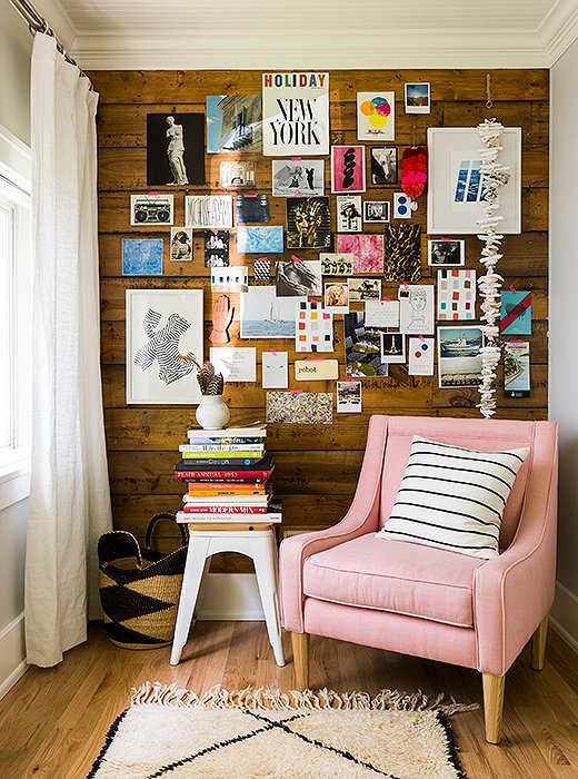 A pastel-pink slipper chair, also part of Michelle’s collection, pops against the wood-paneled inspiration wall in her office.
