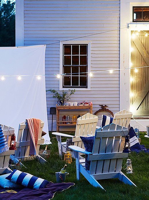 String lights bring an air of magic to any space. Replicate the rest of this cozy look with Adirondack chairs, outdoor pillows, and blankets.
