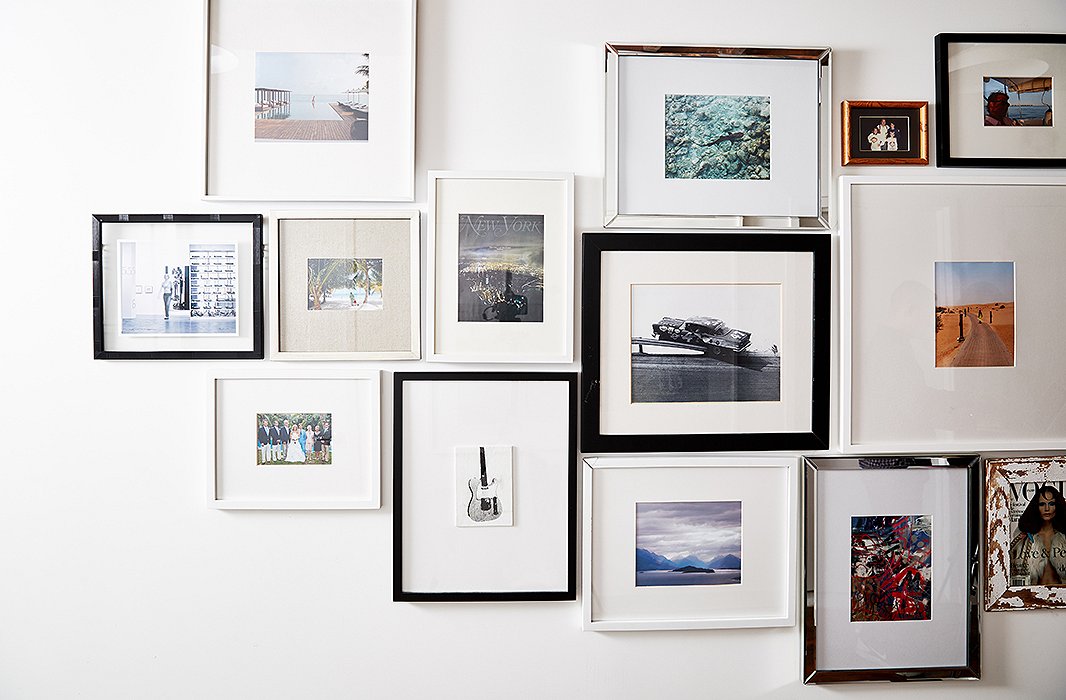 The gallery wall in the couple’s master bedroom showcases photographs from their travels as well as special personal moments.
