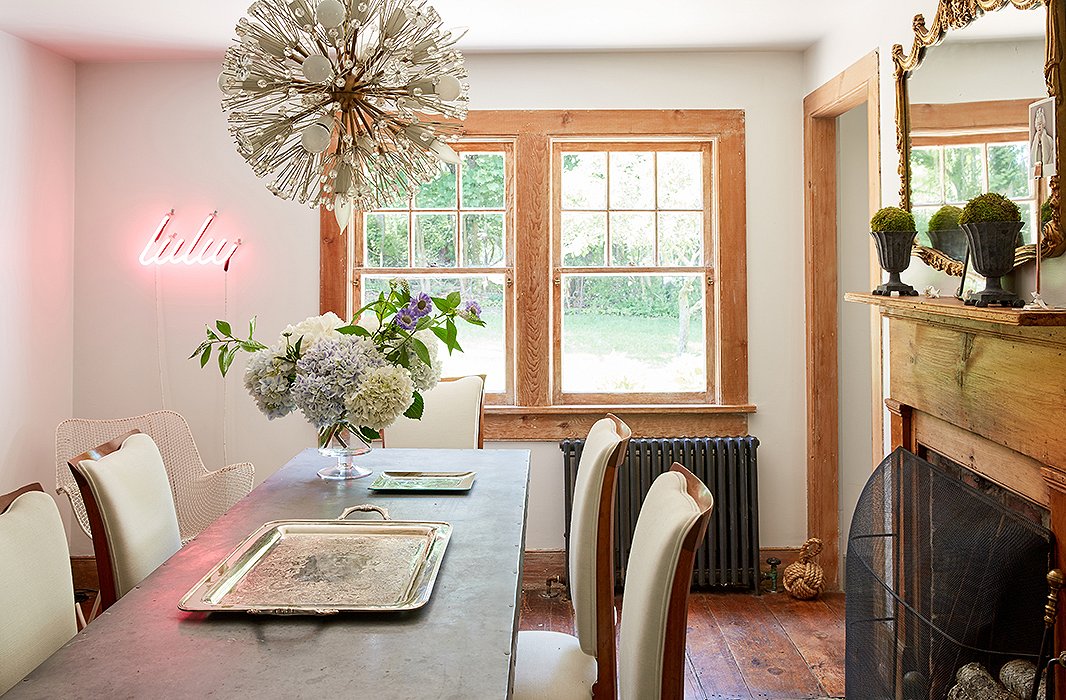 In the dining room, Jennifer blends a mix of styles, from a midcentury glass Sputnik chandelier to an industrial dining table to a trendy neon light fixture emblazoned with her daughter’s nickname.
