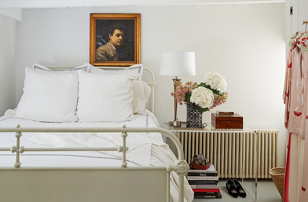 An acrylic console table is a clever alternative to a traditional nightstand in this bedroom.
