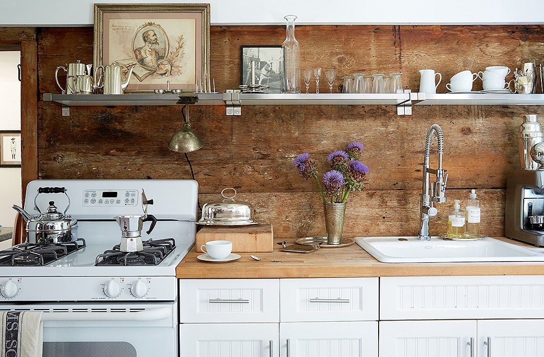 Along with butcher-block counters and stripped wood-plank walls, this kitchen has another element common to farmhouse-style kitchens: open shelving. Though these shelves are industrial steel, they don’t detract from the overall effect. Photo by Tony Vu
