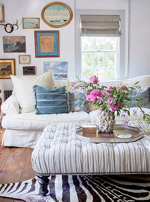 Here, a ticking stripe ottoman acts as a neutral—the perfect mate to hide rugs and vintage global throw pillows alike. Photo by Tony Vu.
