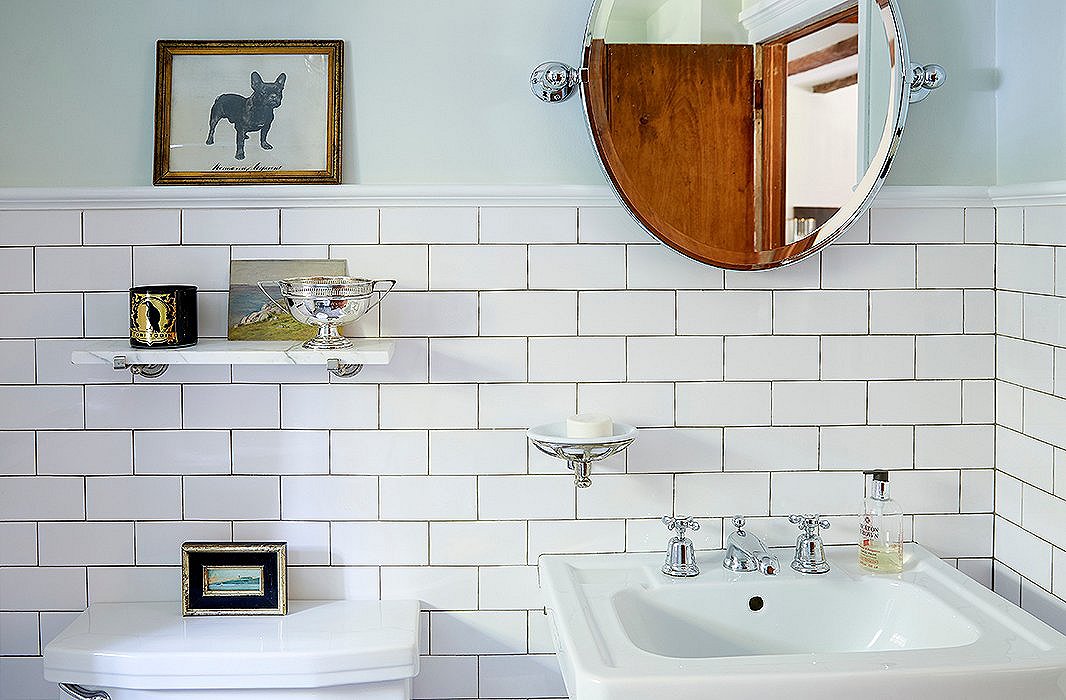 The bathroom was painted in a baby-blue faux-woodgrain pattern when the couple purchased it. In addition to tiling it, they painted the walls “a sort of Ladurée green. It’s just really soft and gives it a little bit of character,” Jennifer says.
