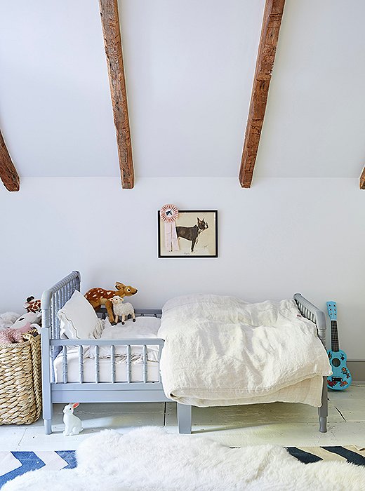 Tallulah sleeps in a pale blue vintage-inspired spindle bed.
