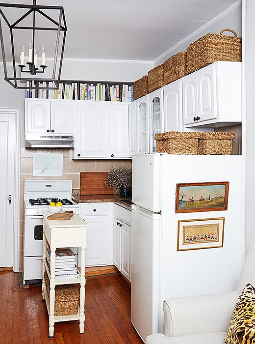 Alex found clever ways to display Cole’s growing art collection—including the side of the refrigerator. “It disguises the appliance that sits right next to the sofa,” says Alex. “Now it feels softer and more a part of the living arrangement.” He used adhesive hooks to hang the landscape prints.
