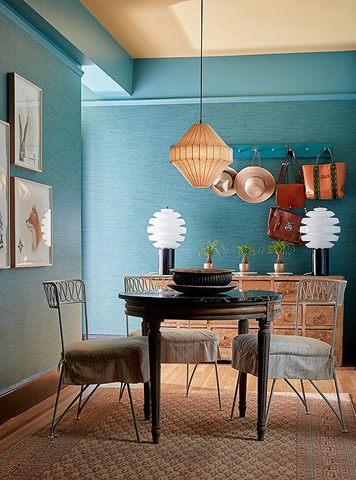 Jaymere wanted the first room in her apartment to be more of an entry than a dining room, as Michelle had had it when she lived there. “She skipped the dining altogether, except for that little round table that seats four,” Michelle says. Jaymere’s love for vibrant color—she had painted the ceiling yellow and installed the teal grass-cloth wallpaper before hiring Michelle—is quite evident.
