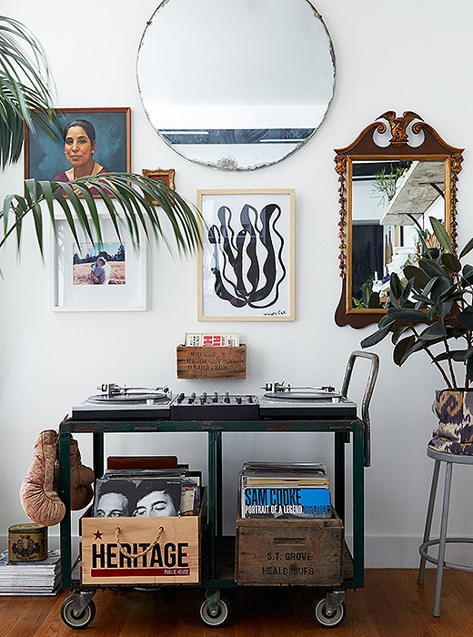 “I have two turntables, a mixer, speakers, and records,” Rosie says. “It can take up space and be a bit of an eyesore.” But she found an attractive solution in the form of her dad’s old tool cart. And she created a chic gallery wall above the cart with a mix of mirrors and art.
