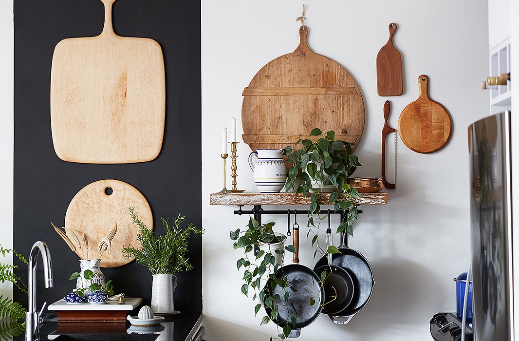 A mod black-and-white kitchen needed some organic ingredients. Enter an array of vintage cutting boards. Rosie approached the project as if it were a gallery wall. A hanging pot rack was practical (they cook a lot) and looks great.
