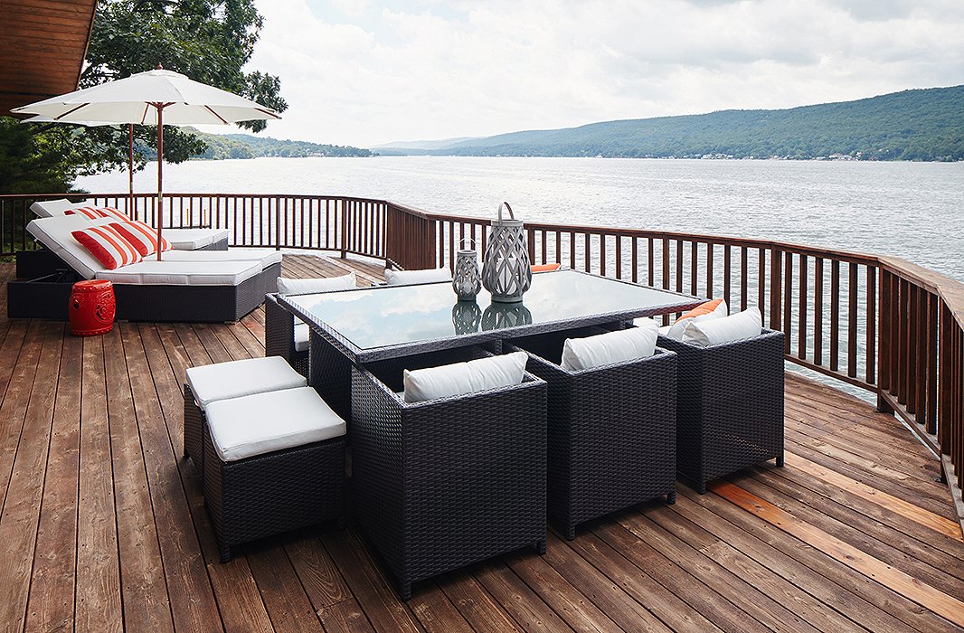 On the color wheel, orange sits opposite blue, which makes this Morris garden stool and the orange-stripe cushions the perfect complement to this lakeside scene. Photo by Mark Weinberg; design by One Kings Lane Interior Design.
