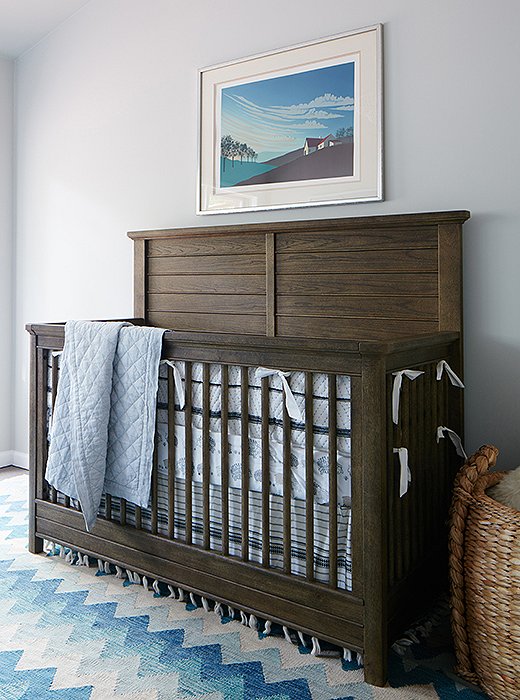 A gym was transformed into a cheery kids’ room with a crib and a sofa with a trundle bed. A bright vintage rug tops the spill-friendly carpet tiles.
 
