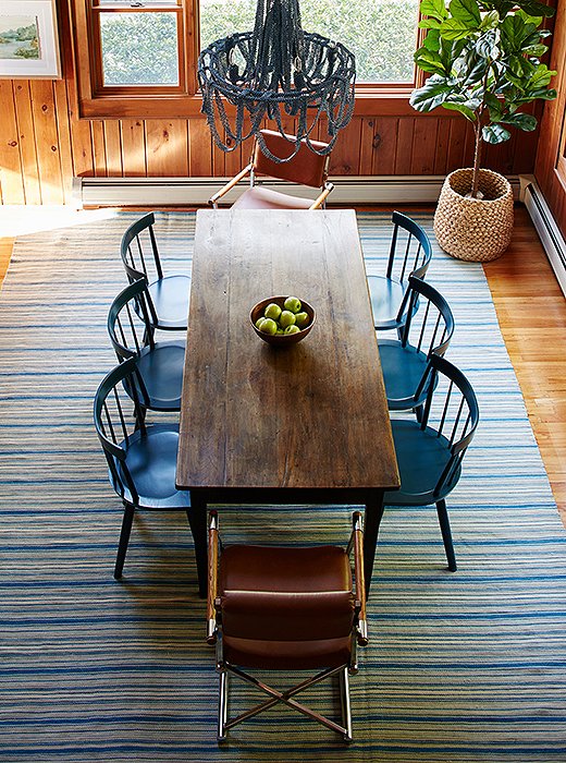 The dining room’s long vintage table can fit a crowd. The blue lacquered chairs (durable for little ones!) and vintage leather armchairs elevate the look.
