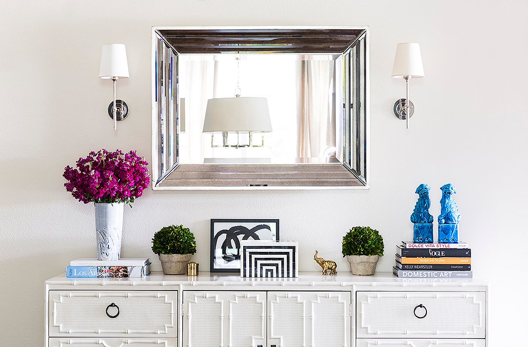 Part of a long hallway, the entry is open to a larger living space; Paloma defined the area without overpowering it. The credenza is from the 1960s and one of the first pieces the couple bought together. The mirror hails from a local store, and the sconces are Thomas O’Brien for Visual Comfort.
