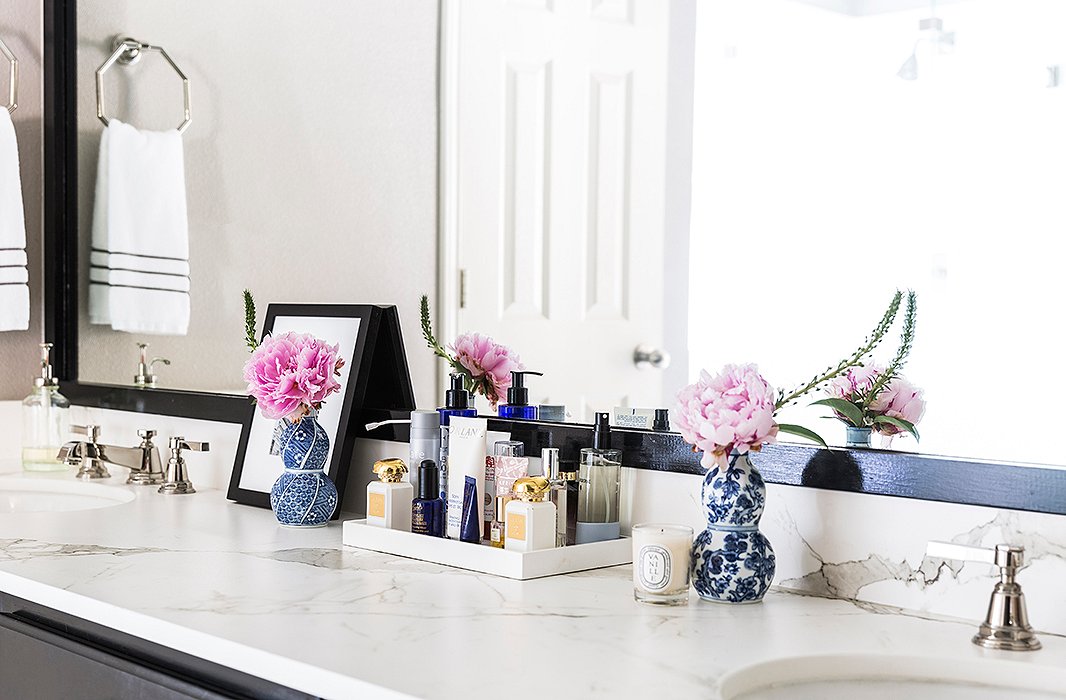 The master bath boasts a picturesque vanity. “Everything should have its place and be hidden if possible,” says Paloma. “If you don’t have room, use trays so it feels neat and collected.” She always opts for timeless materials in baths. “Think marble, a neutral palette, polished-nickel fixtures, and pretty lighting.”
