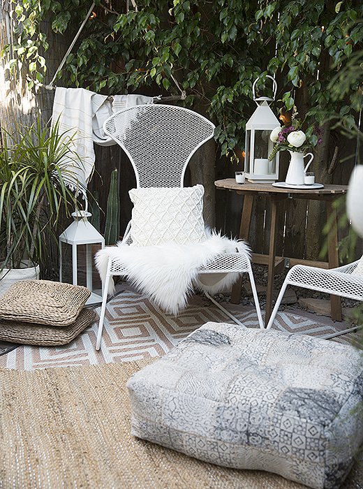 The back garden takes on a Moroccan vibe with low-slung wire chairs, layered rugs, and lots of cozy sheepskin throws, pillows, and cushions.
