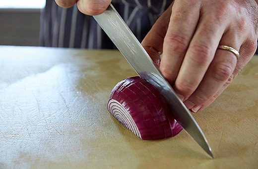 For the red onions, first throw out the skin, then put the end bits into the purée bowl. Next, with one end up, cut in half vertically. Slice as shown above, keeping your fingers curved inward.
