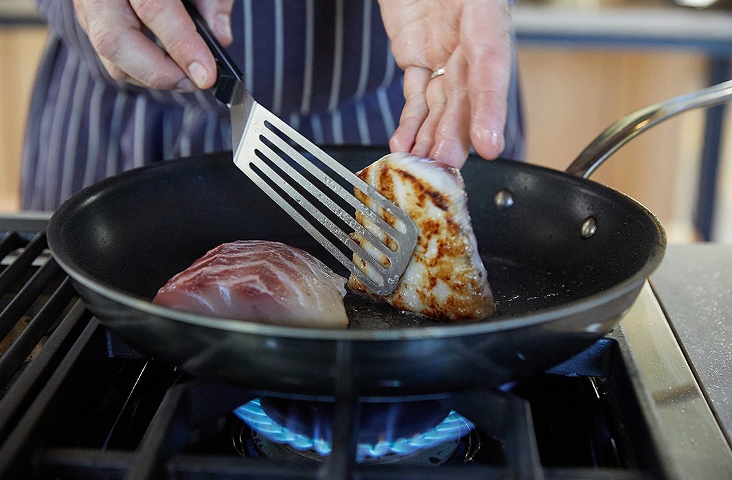 Greg peeks at the bottom of the fish: perfectly browned and ready for the oven.
