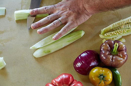 The majority of the cucumber, especially if it has seeds, will end up in the purée. First, peel the cucumbers, then quarter them lengthwise, and core; put the core and seeds in a strainer on top of the purée mixture and add some salt to draw out more liquid. That gives you a flat side, making it easier to dice.
