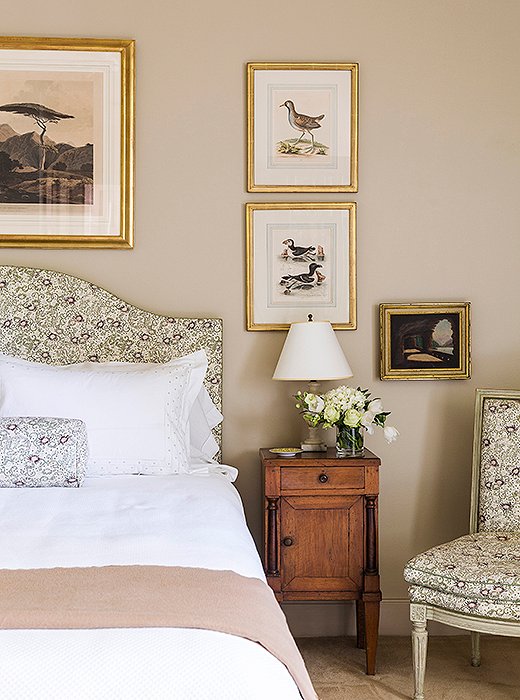 Julia’s bedroom is beautifully appointed with a headboard, Louis XVI side chair, and bolster all upholstered in an elegant floral fabric.