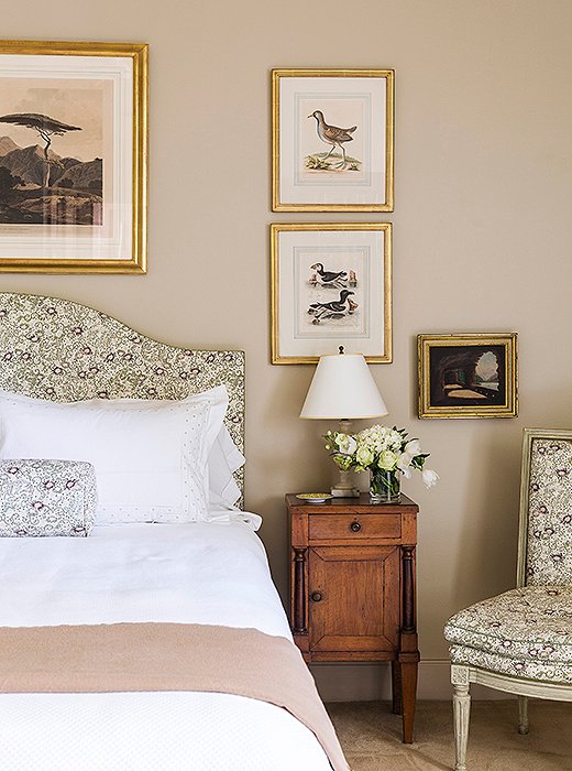 Julia’s bedroom is beautifully appointed with a headboard, Louis XVI side chair, and bolster all upholstered in an elegant floral fabric.
