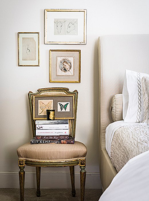 A side chair stacked with books serves as a makeshift nightstand in the author’s second bedroom.
