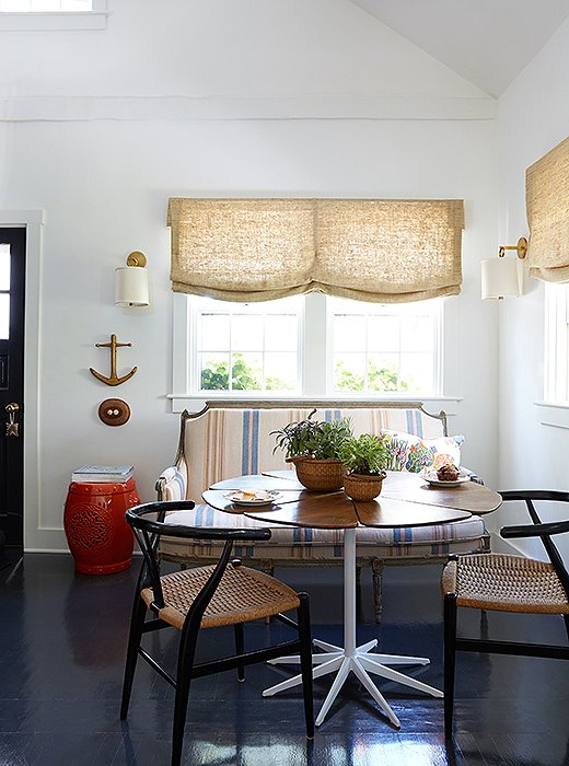 The handsome dining nook suits the family’s casual summer style—and doubles as a place for Elizabeth to pull out her laptop for work when need be. Vintage elements, in the form of a Knoll Petal table, Wegner chairs, and a classical settee—which the designer scored at one of the Paris flea markets and had reupholstered in an evergreen blue-and-orange stripe—up the charm factor.
