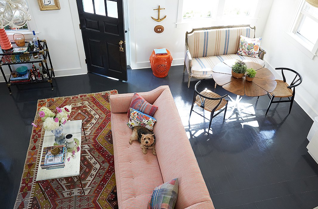 The dark floors contrast perfectly with Elizabeth’s more upbeat choices (“I do love color, and I do love pattern,” she admits). Overall the decorator took her design cues from the seaside location, making sure to nail that “old Nantucket spirit” without being overly reverential. “These are the original floors,” she notes. “We were going to rip them out but instead decided to sand them down and paint them a historical gray.” Find a similar garden stool here.
