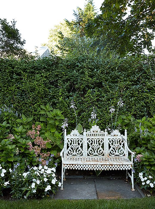 A lovely vintage garden bench provides the busy mom with a place to take a breather. “When I’m here, I’ll pick flowers and make arrangements and place them throughout both [ours and my parents’] houses,” Elizabeth says. “I enjoy flower arranging, but I can’t say that I’m a great gardener—my mom’s the one with the green thumb.”
