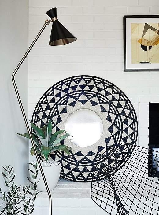 The clean lines of the wall became especially striking once the fireplace’s interior was painted a fireproof black and the mirror and the Bertoia chair were added.
