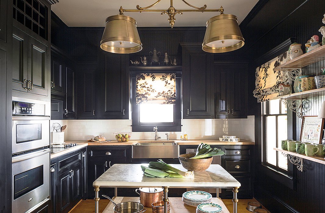 The kitchen had been renovated by the previous owner but wasn’t Bailey’s style. Since the room doesn’t get much light, the designer embraced the darkness by painting the cabinets a glossy black. She added a fixture from Circa Lighting as a nod to the home’s rich past. “I just wanted something that felt kind of Victorian but then also had a modern vibe to it.”
