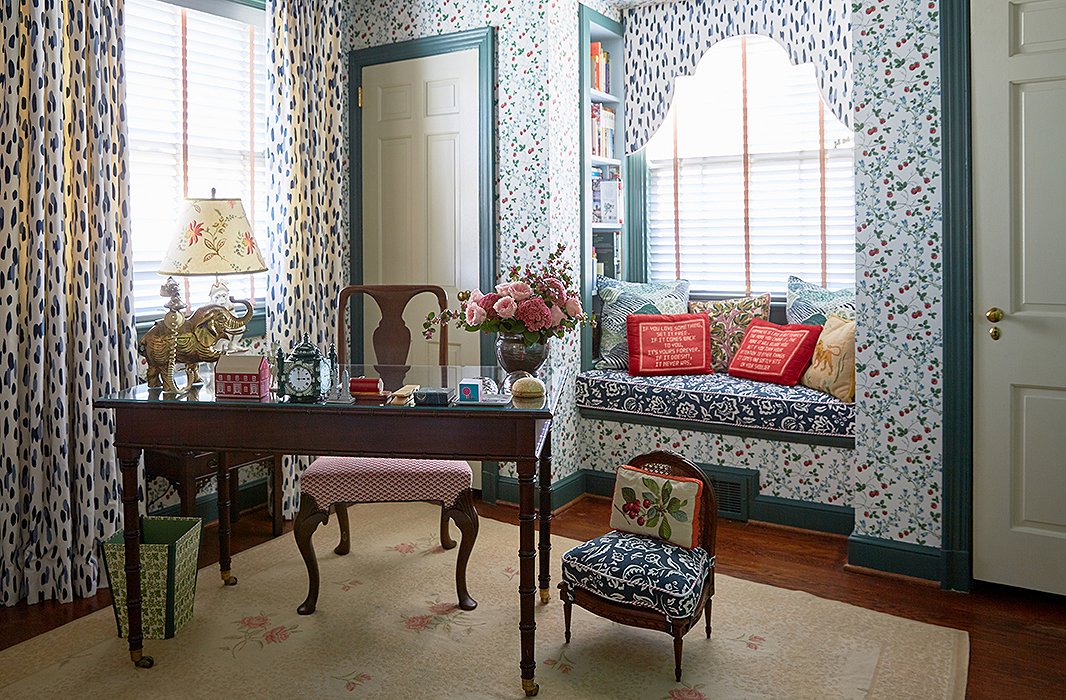 The designers scored a vintage strawberry wallpaper from Brunschwig & Fils and used a mix of Madcap Cottage fabrics and needlepoint pillows from the estate of C.Z. Guest to create a cozy reading nook.
