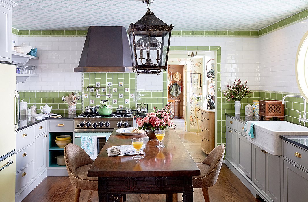 Designers Jason Oliver Nixon and John Loecke of Madcap Cottage took inspiration from the Royal Pavilion in Brighton, England, for their kitchen. The Belfast sink complements the vintage lanterns and the 18th-century wood table they converted into an island. Photo by Tony Vu.
