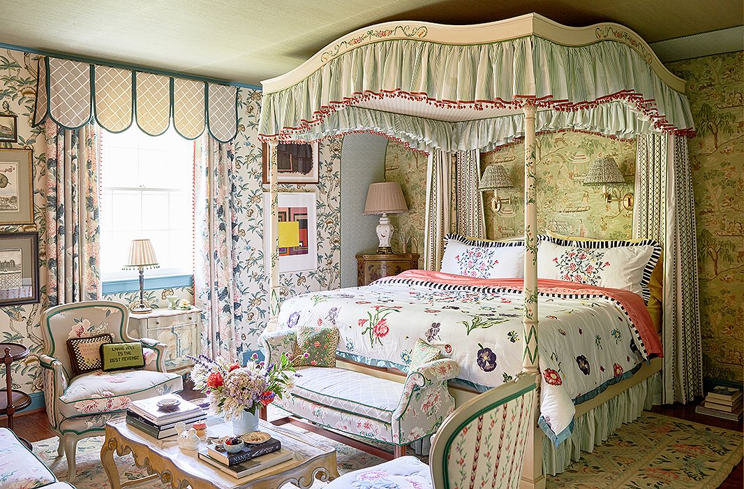 John and Jason used an “explosion of print and pattern” in the master bedroom. “It feels very much of the house in its heyday but contemporized,” says Jason. A decorative painter added chinoiserie details to the canopy bed’s original floral motifs. “You can take something that you buy and reinvent it and add a further spin of your own,” John says.
