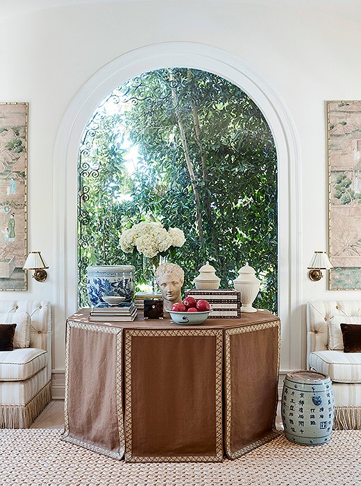 “A skirted table adds a feminine and sophisticated touch to a room,” says Mark. “And they’re practical—you can stow things out of sight.” The bust was found in Charlotte, NC; the bowls are from San Francisco; and the books are a small part of a sizable library. “We have books everywhere,” he says. “They’re under tables, used as side tables. When I try to find a particular one, it’s quite the hunt.”
