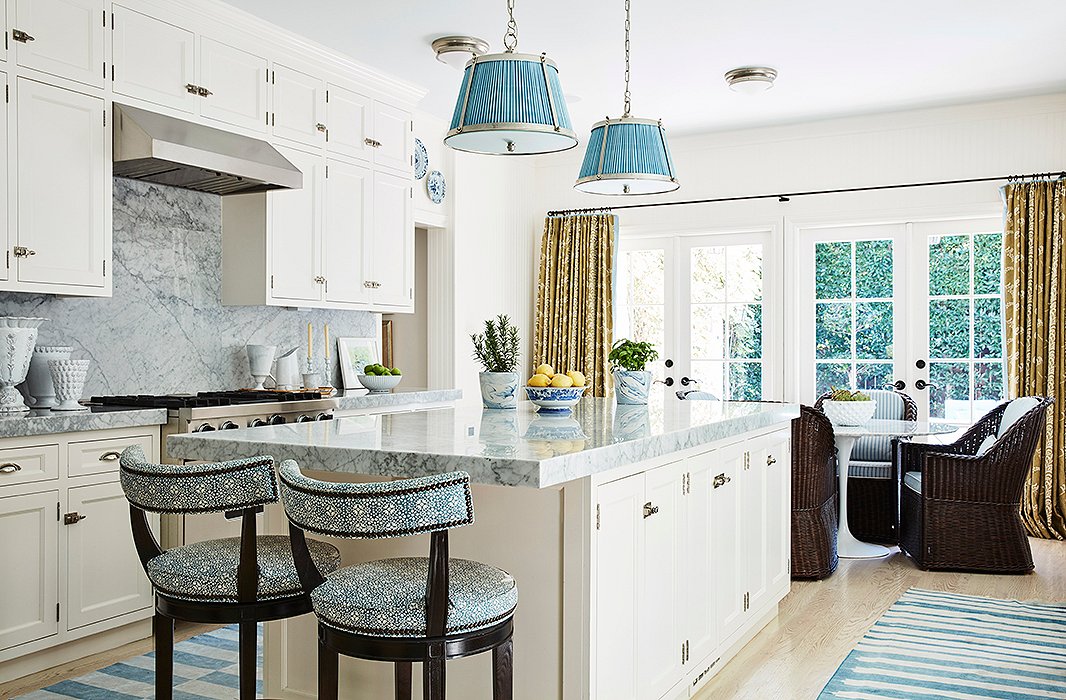 The designer combined the original galley kitchen and adjoining maid’s room to achieve an open, airy blue-and-white space that is another multifunctional area. “We don’t cook a lot, so it really serves as a family room,” says Mark. “The TV is here, and we have lots of seating areas.”
